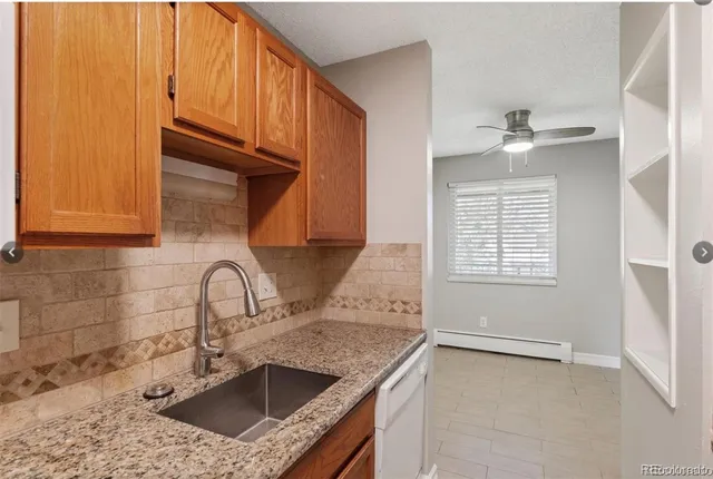 a kitchen with a granite countertop sink stove and cabinets