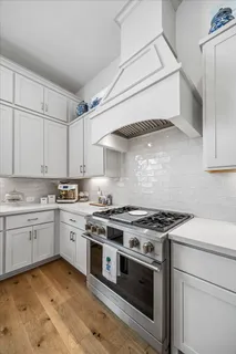 a kitchen with granite countertop white cabinets and white stove