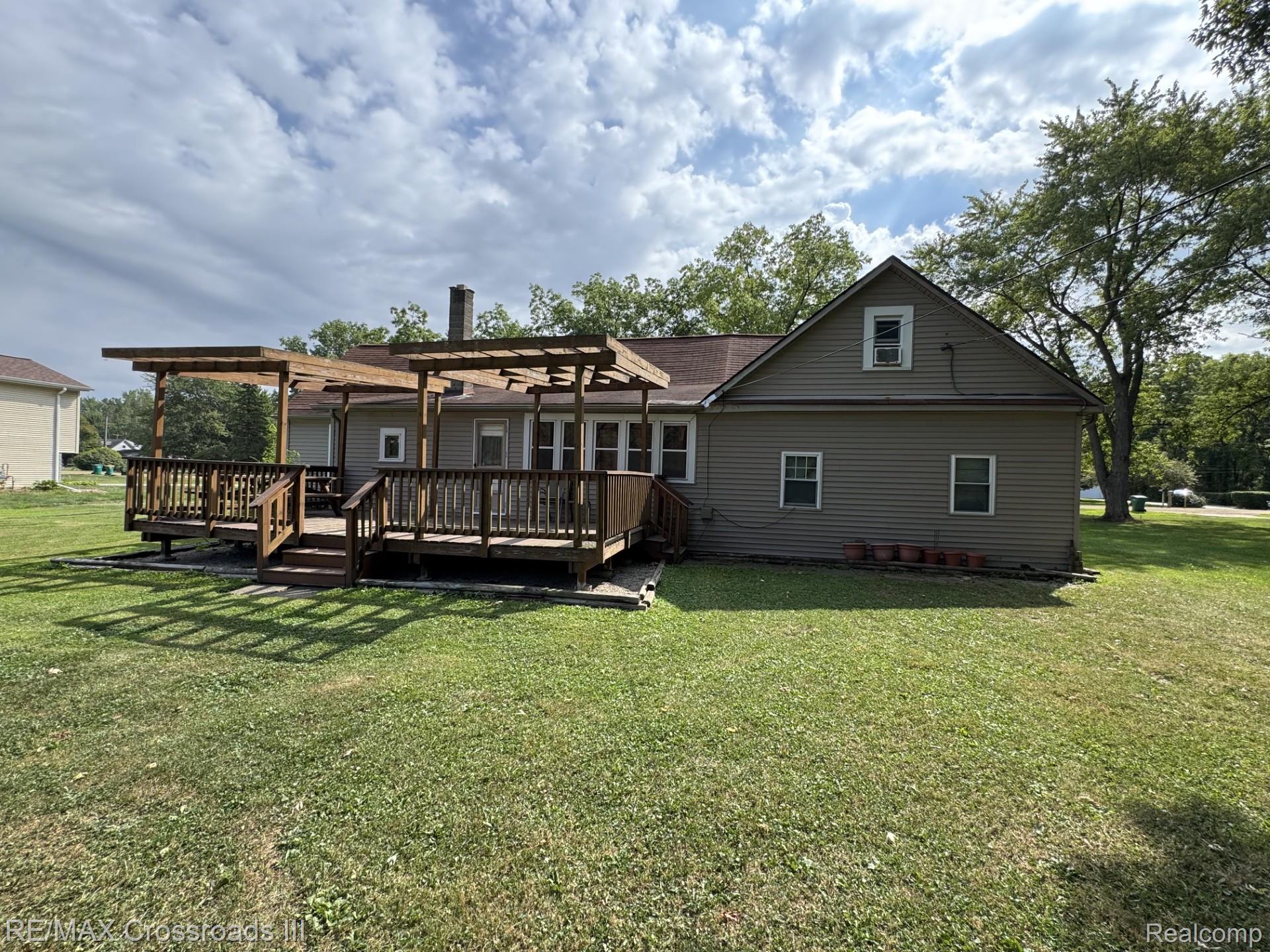 7150 Sheldon Road Belleville, MI 48111 - Photo 11 of 11 Expansive backyard featuring a large wood deck, pergola, and mature trees