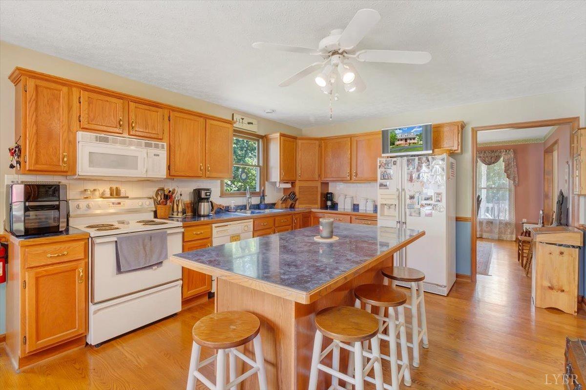 737 Homeplace Road Rustburg, VA 24588 - Photo 12 of 73 a kitchen with stainless steel appliances granite countertop a stove top oven a sink dishwasher and white cabinets with wooden floor
