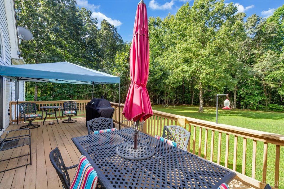 737 Homeplace Road Rustburg, VA 24588 - Photo 45 of 73 a view of a patio with a dining table and chairs with wooden floor and fence