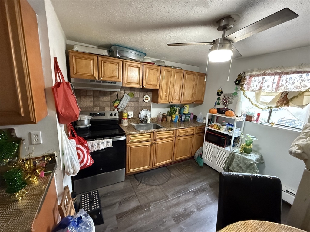 16 A Exeter Street Lawrence, MA 01843 - Photo 5 of 12 a kitchen with stainless steel appliances granite countertop a stove sink and cabinets