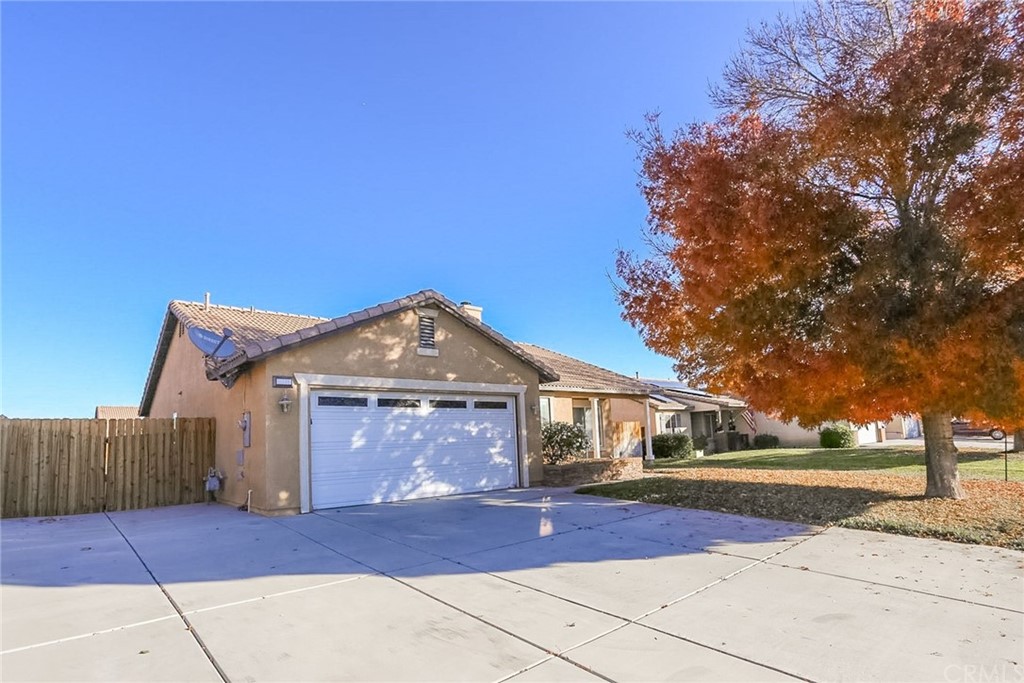 11786 Marshal Road Adelanto, CA 92301 - Photo 1 of 1 a front view of a house with a yard and garage