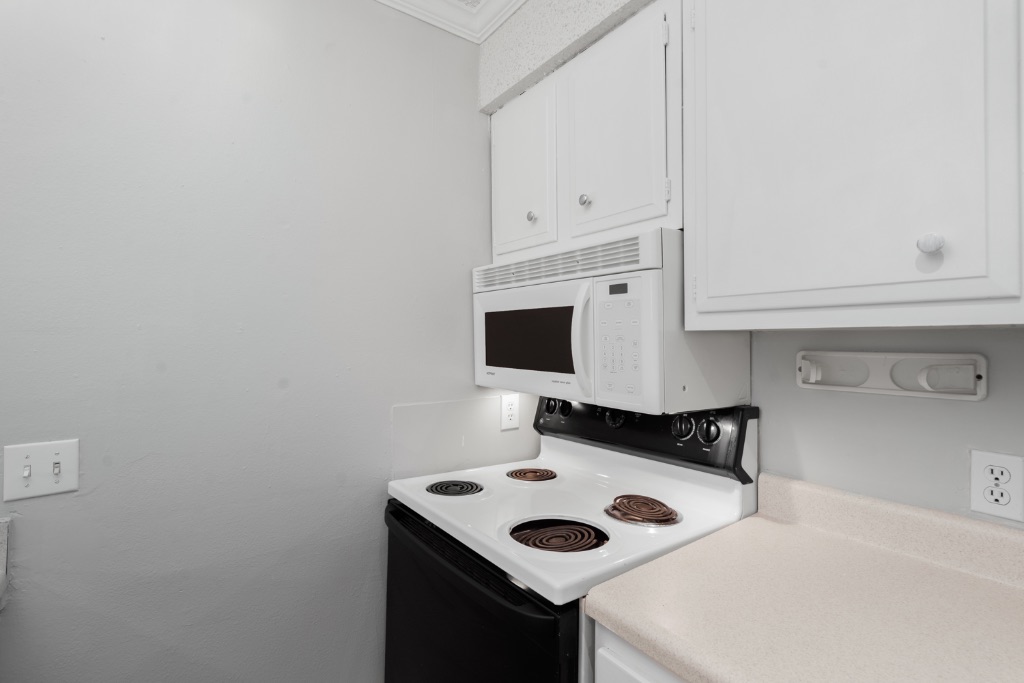 4103 Speedway, Unit 105 Austin, TX 78751 - Photo 8 of 10 Kitchen with white appliances, white cabinets, and light countertops