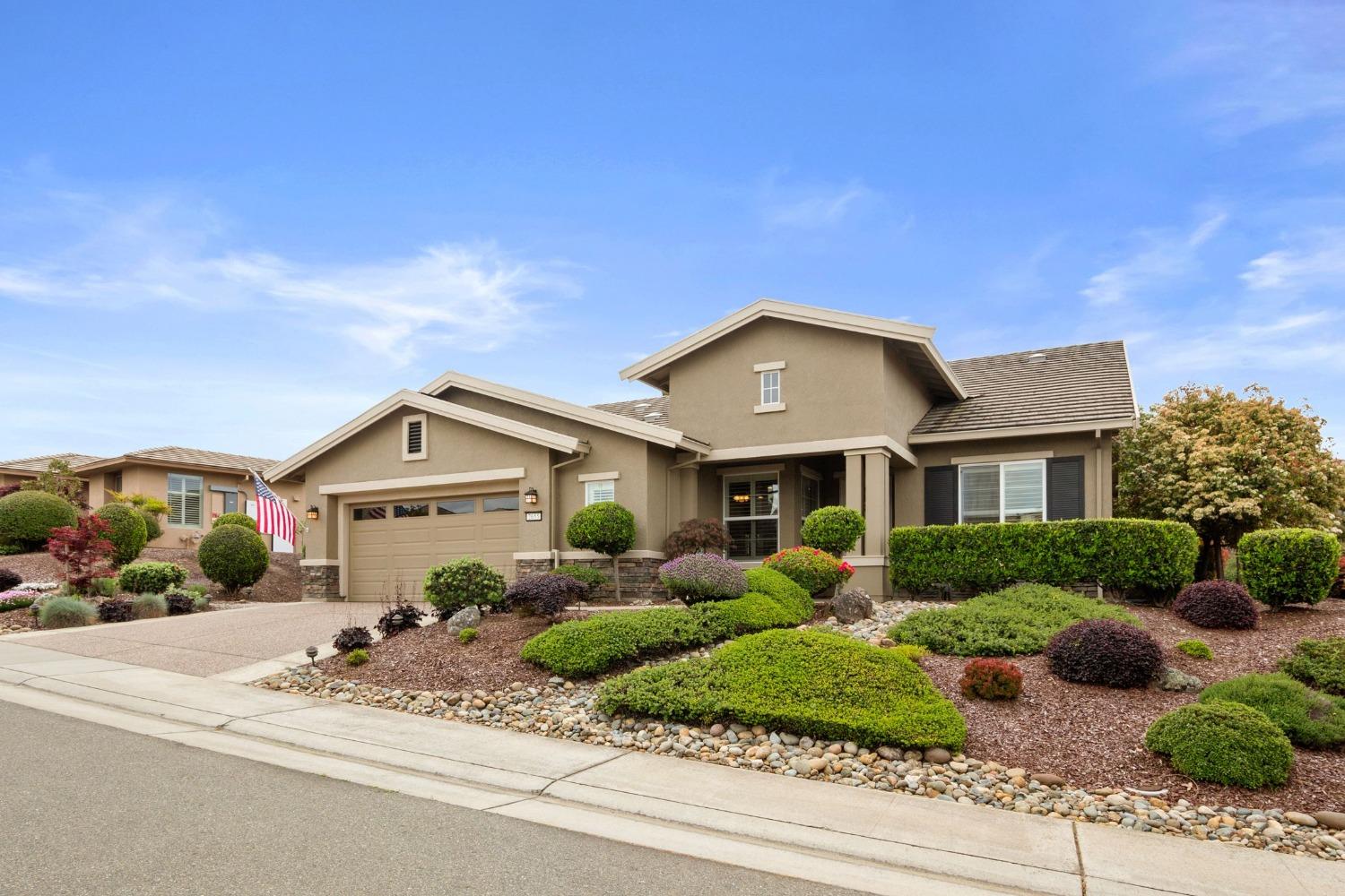 a front view of a house with a yard and potted plants
