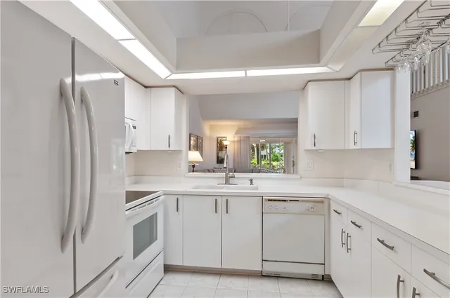 a kitchen with white cabinets and white appliances