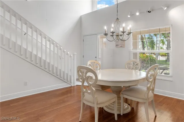 a view of a dining room with furniture a chandelier and wooden floor