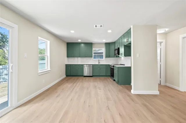 a view of kitchen with wooden floor and electronic appliances