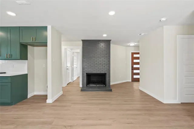 an empty room with wooden floor and a fireplace