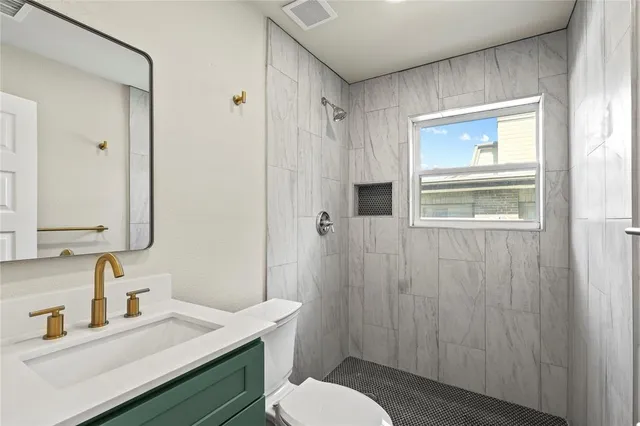 a bathroom with a sink a toilet and shower