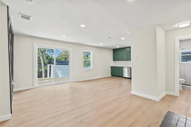 a view of a livingroom with wooden floor and a fireplace
