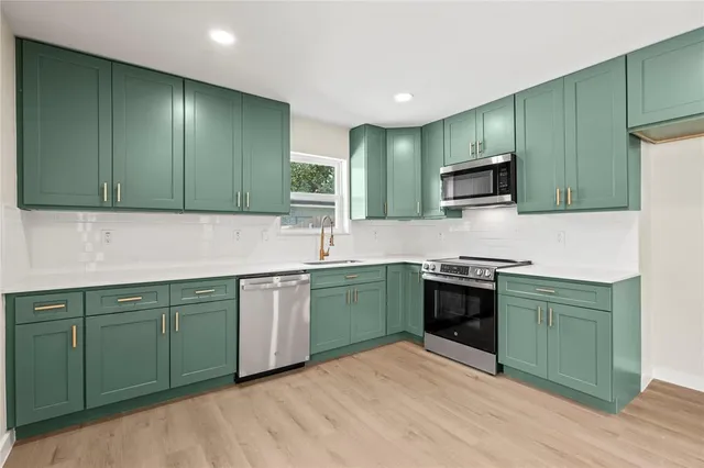 a kitchen with lots of counter top space sink and stainless steel appliances
