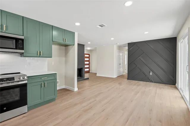 a kitchen with stainless steel appliances kitchen island granite countertop a refrigerator and a stove top oven