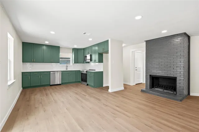 a view of kitchen with sink and refrigerator