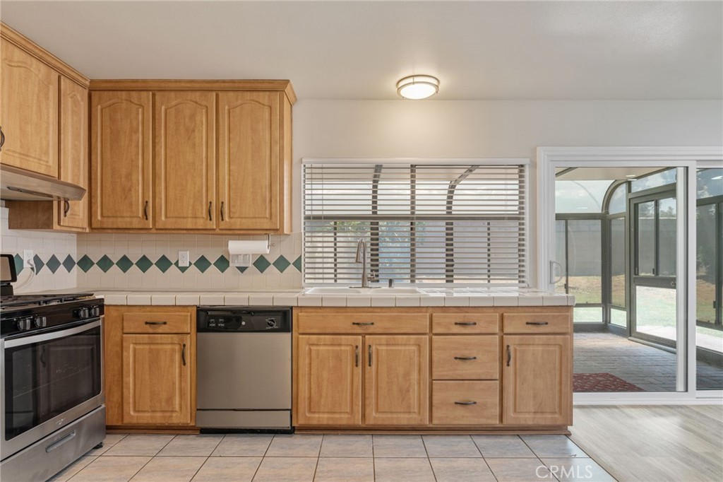 1708 East Cyrene Drive Carson, CA 90746 - Photo 11 of 26 a kitchen with a stove sink and cabinets