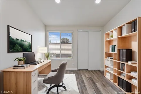 a view of a workspace with furniture and a window