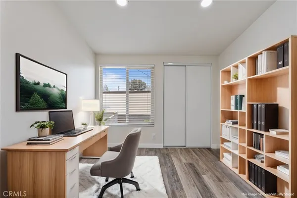 a view of a workspace with furniture and a window