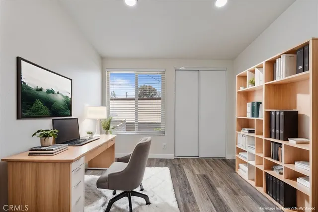 a view of a workspace with furniture and a window