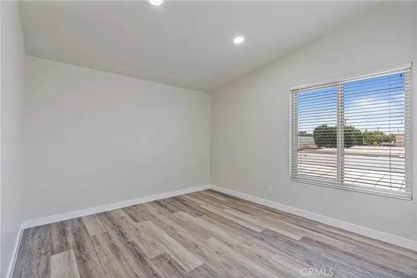 a view of a room that has wooden floor and a window