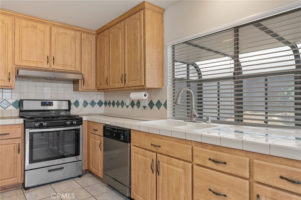 1708 East Cyrene Drive Carson, CA 90746 - Photo 9 of 26 a kitchen with granite countertop white cabinets and a stove