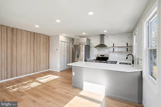 a large white kitchen with kitchen island a sink stainless steel appliances and cabinets