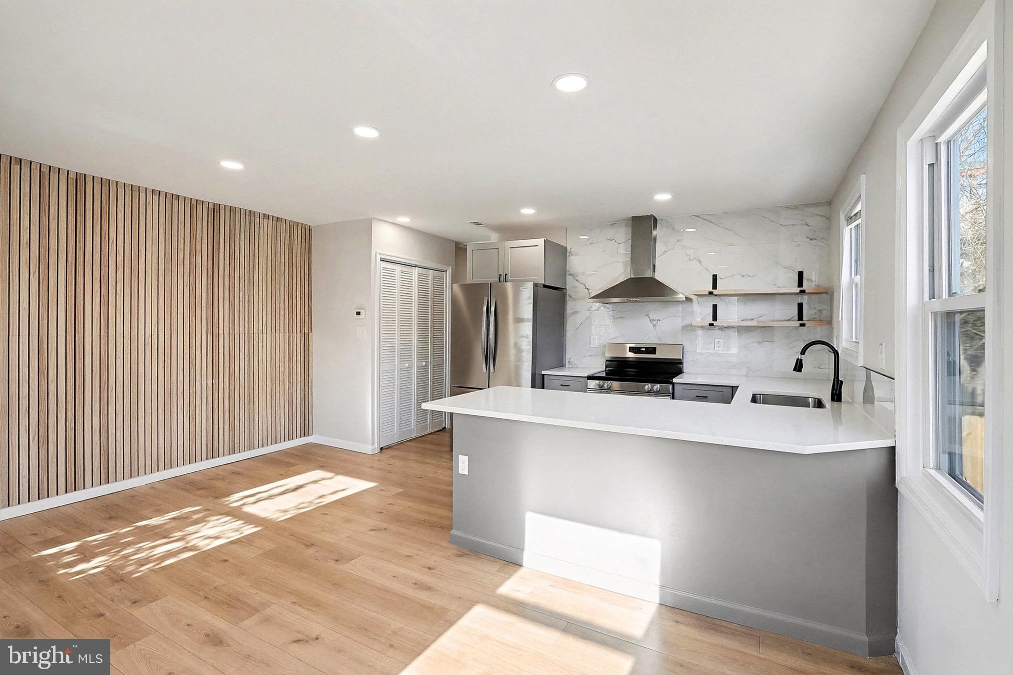40 East Reed Avenue Alexandria, VA 22305 - Photo 4 of 19 a large white kitchen with kitchen island a sink stainless steel appliances and cabinets