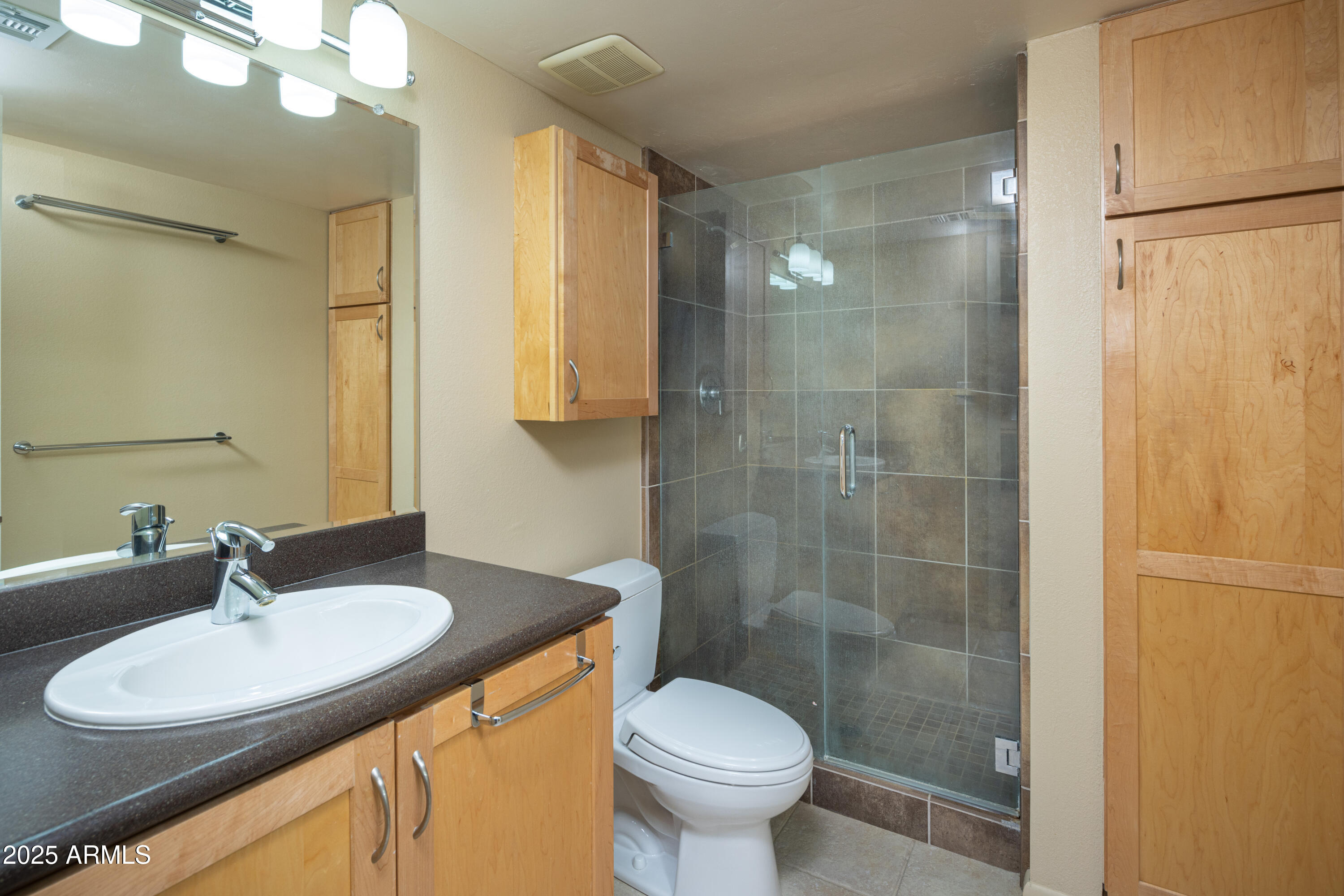 7830 East Camelback Road, Unit 708 Scottsdale, AZ 85251 - Photo 13 of 21 a bathroom with a sink toilet a mirror and shower