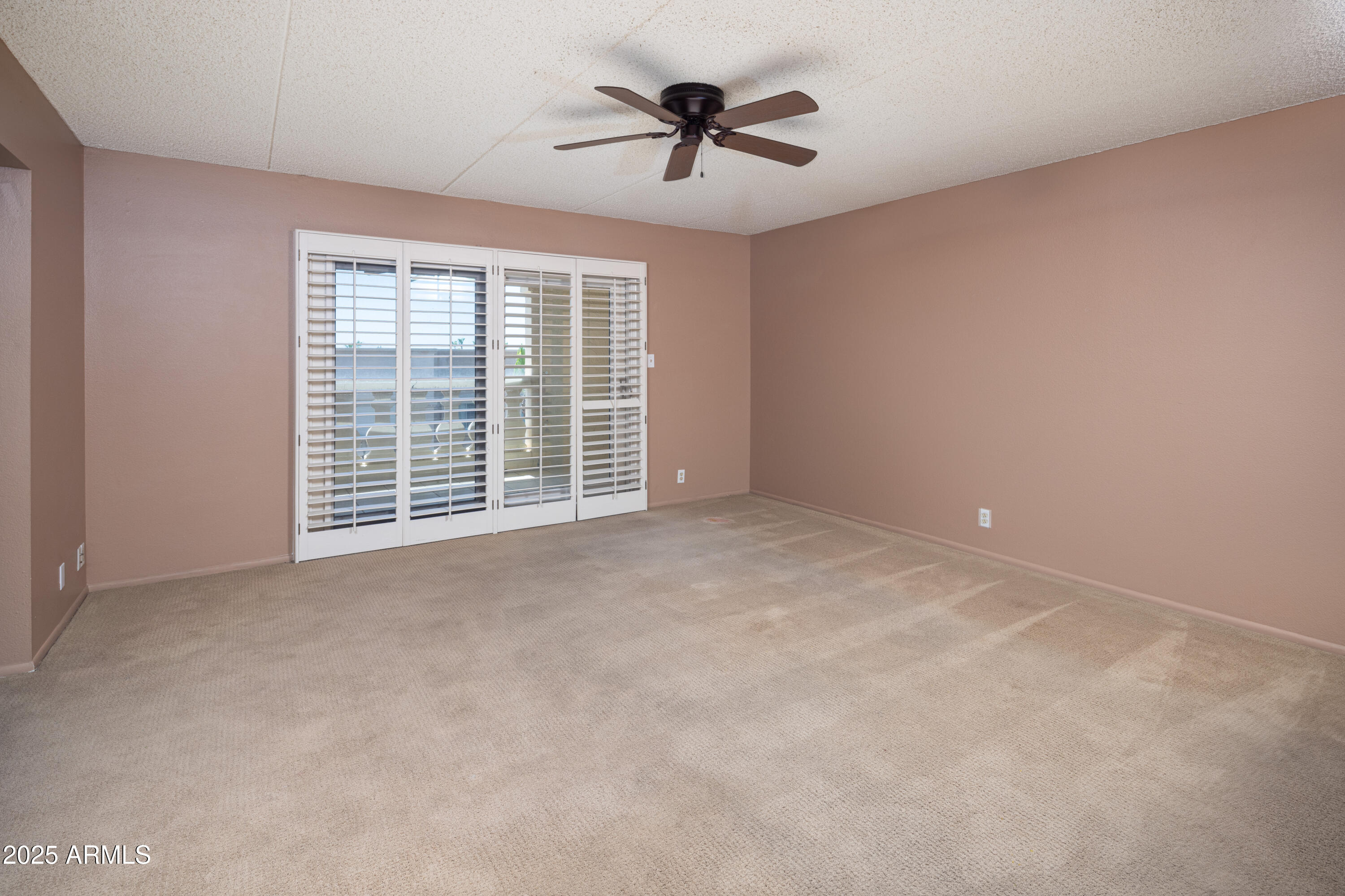 7830 East Camelback Road, Unit 708 Scottsdale, AZ 85251 - Photo 6 of 21 a view of an empty room with a ceiling fan and window