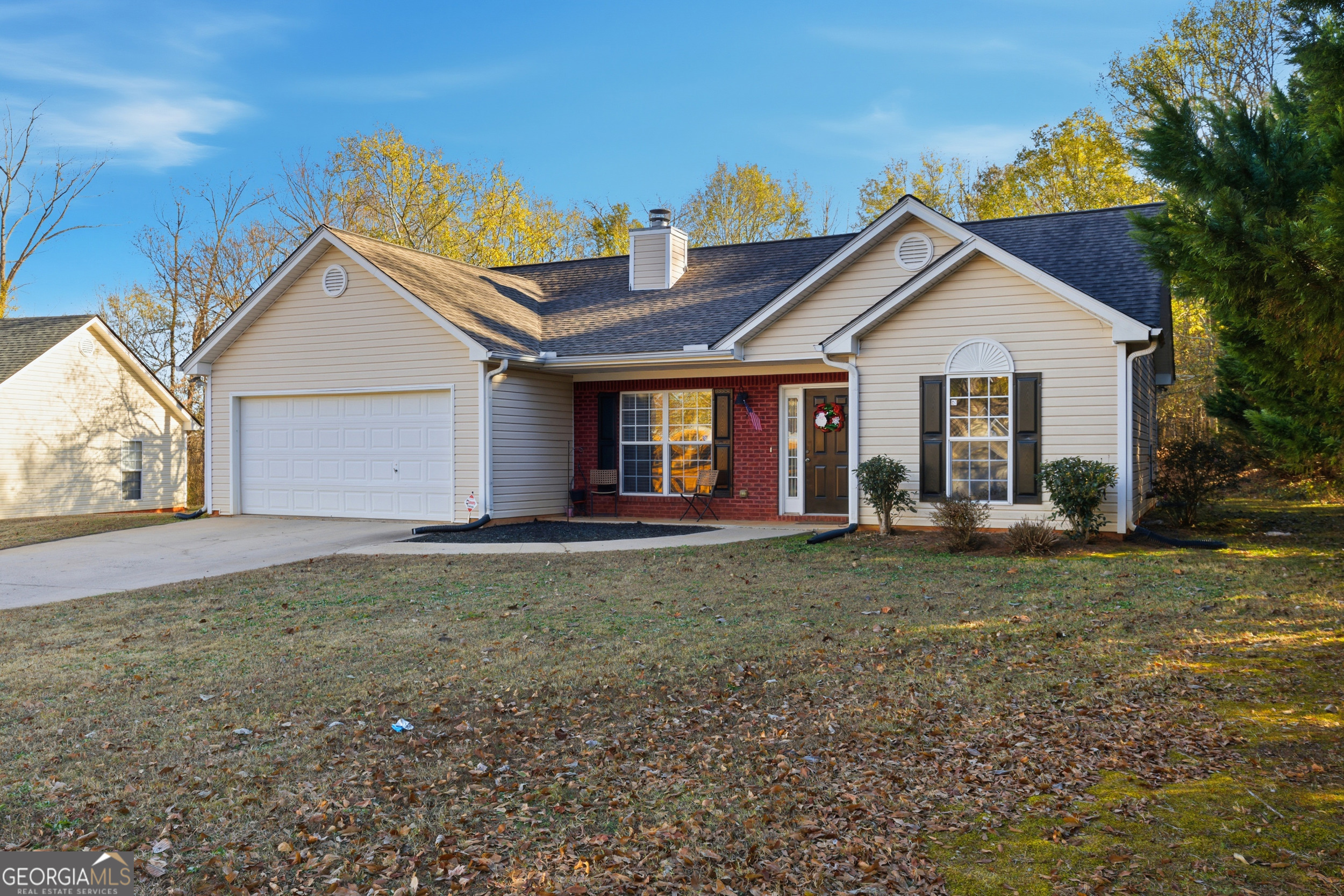 a view of a house with a yard and large tree