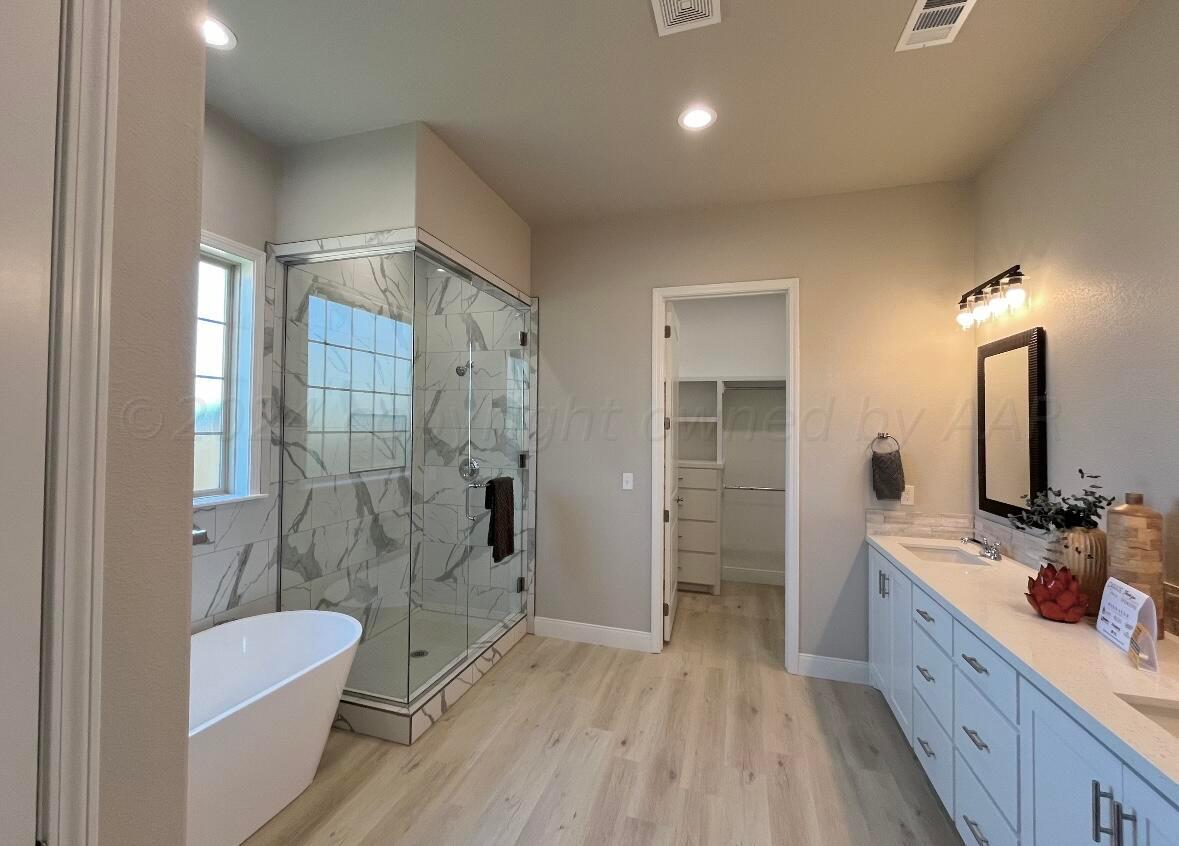 7616 Bluestone Drive Amarillo, TX 79119 - Photo 7 of 10 a bathroom with a double vanity sink a toilet a mirror and shower