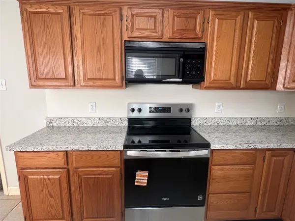 a kitchen with granite countertop cabinets sink and window