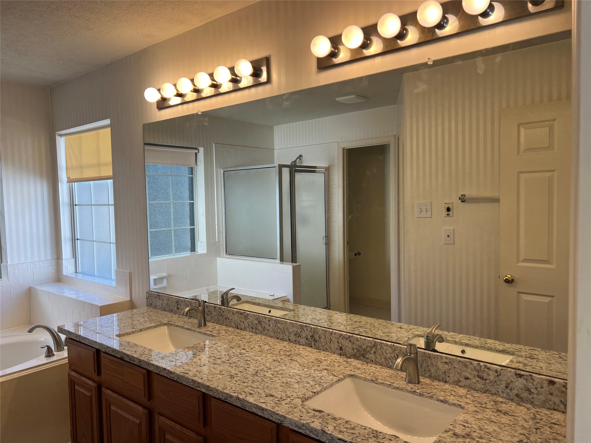 811 Spring Valley Court Sugar Land, TX 77479 - Photo 31 of 33 a bathroom with a granite countertop sink a large mirror and a shower