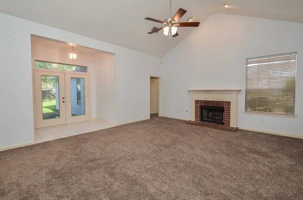 a view of empty room with fireplace and fan