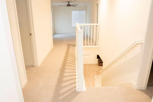 a view of a hallway with a white walls and stairs