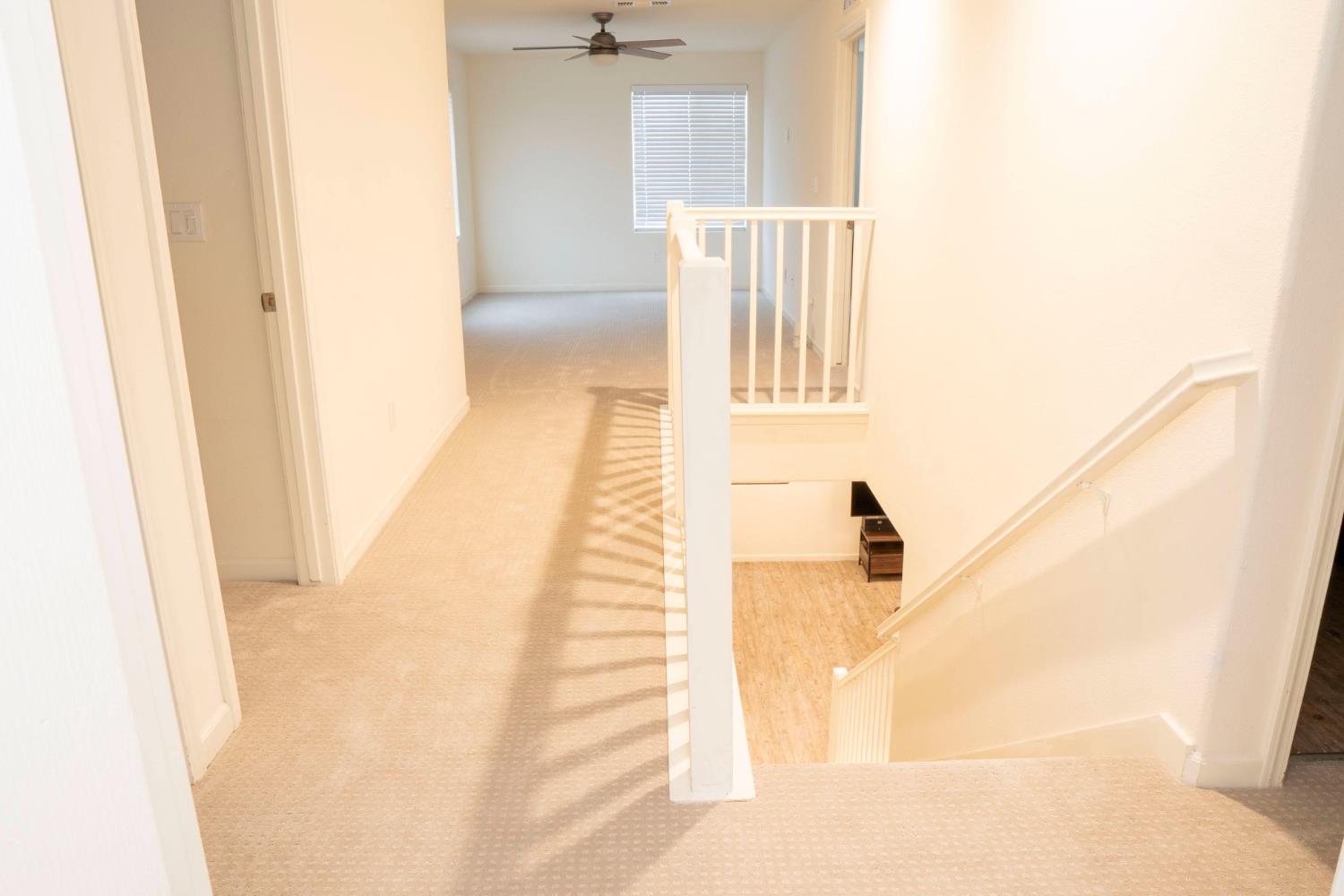 6974 East Atchison Street Fresno, CA 93727 - Photo 17 of 40 a view of a hallway with a white walls and stairs
