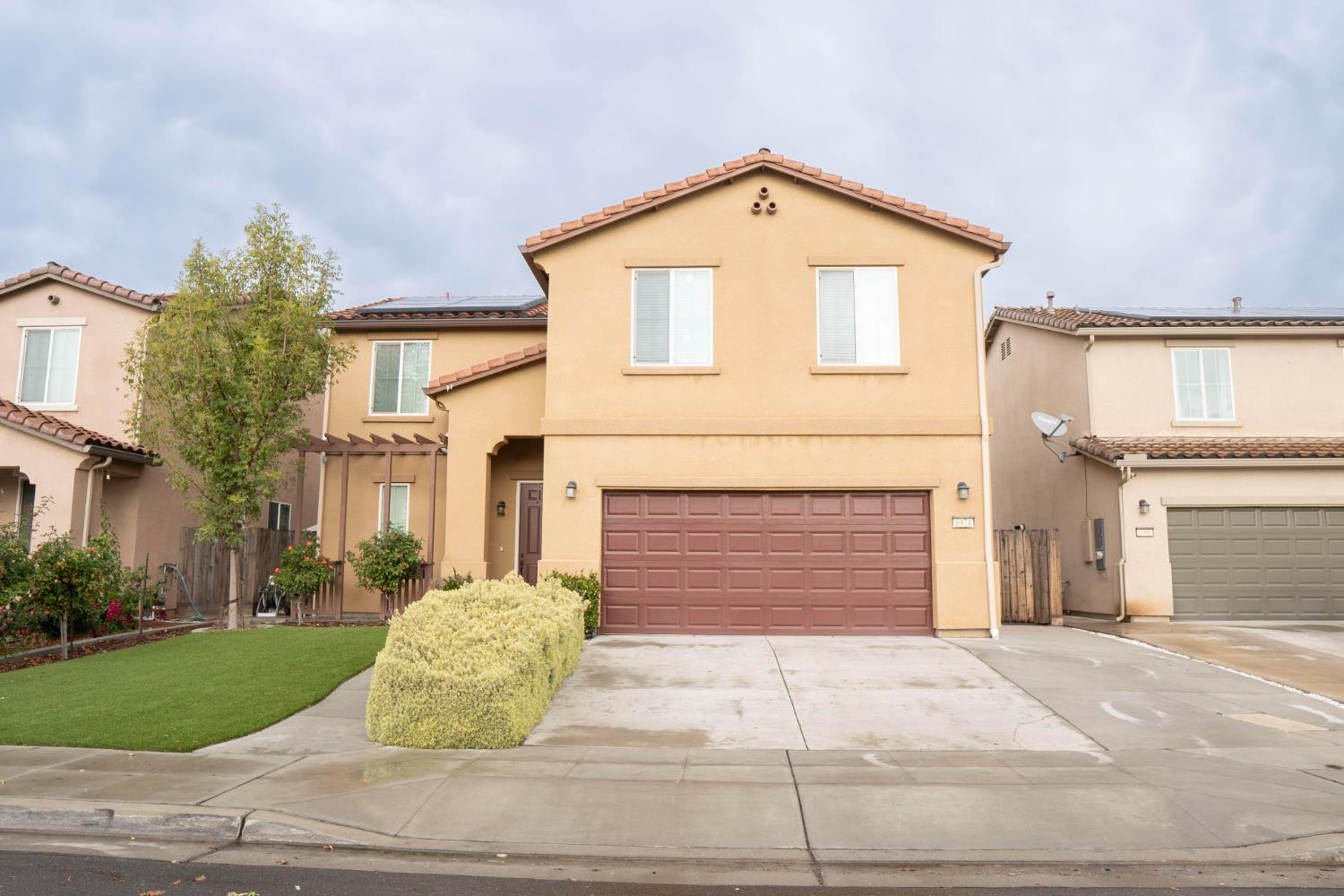 6974 East Atchison Street Fresno, CA 93727 - Photo 2 of 40 a front view of a house with a yard and garage