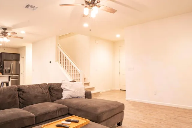 a living room with furniture and a ceiling fan
