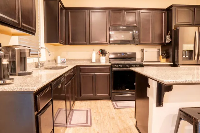 a kitchen with stainless steel appliances granite countertop a sink stove and refrigerator