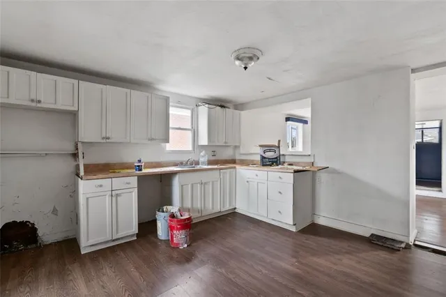 a kitchen with granite countertop white cabinets and white appliances