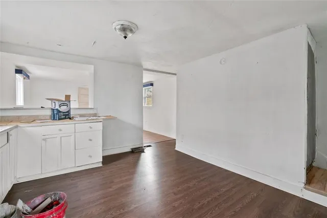 a room with white cabinets and wooden floor