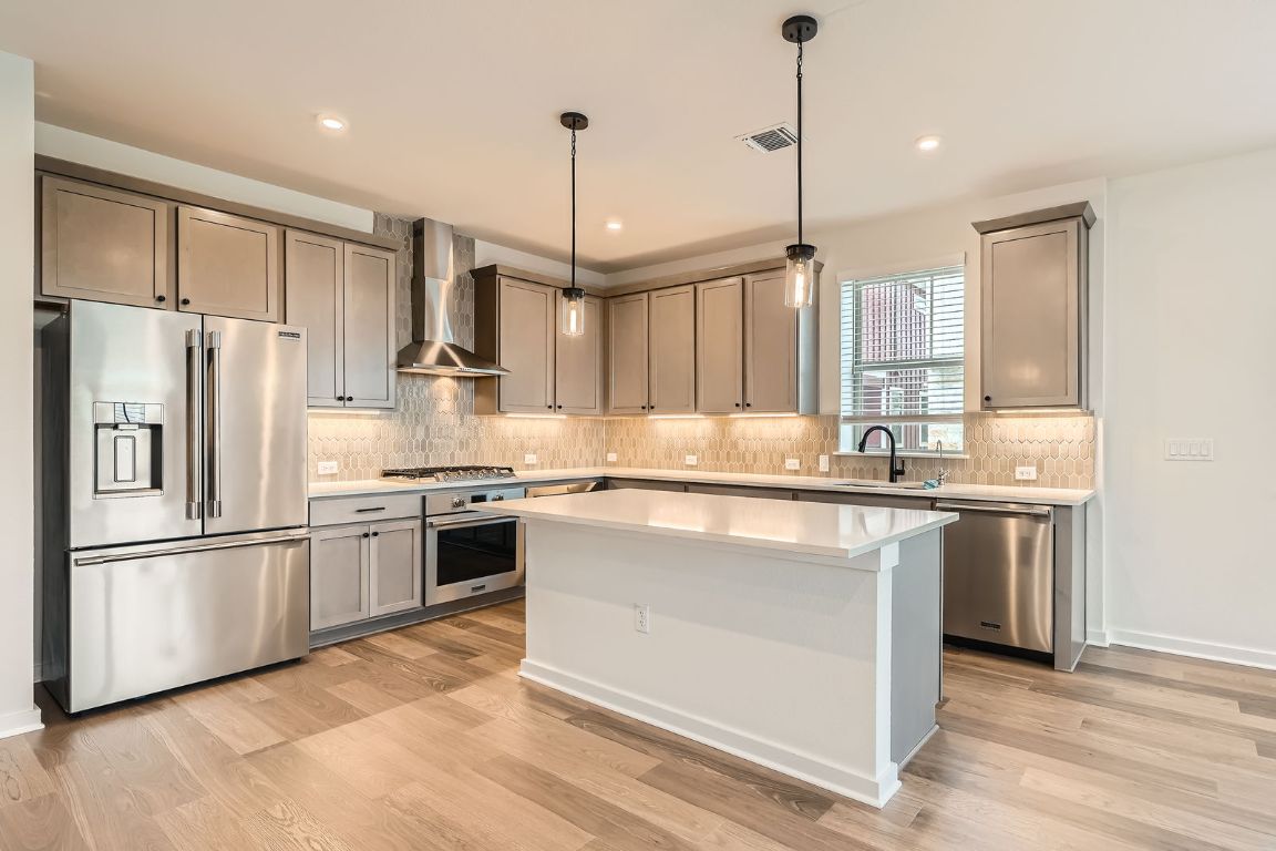 6300 Stockman Drive, Unit 5 Austin, TX 78747 - Photo 11 of 32 a kitchen with stainless steel appliances granite countertop a refrigerator a sink and a stove