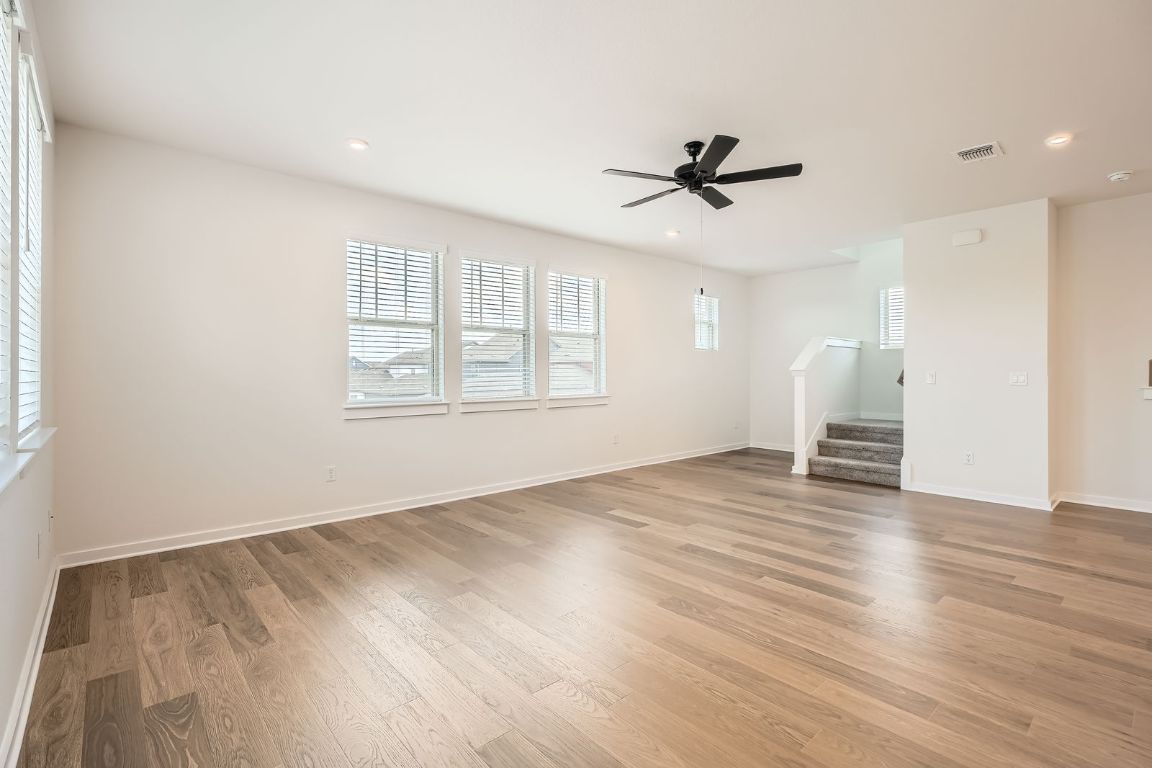 6300 Stockman Drive, Unit 5 Austin, TX 78747 - Photo 15 of 32 an empty room with wooden floor ceiling fan and windows