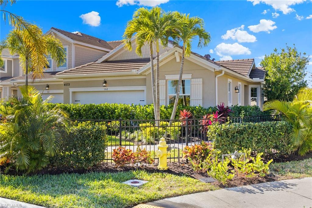 4558 Arboretum Circle, Unit 104 Naples, FL 34112 - Photo 1 of 19 a front view of a house with a yard