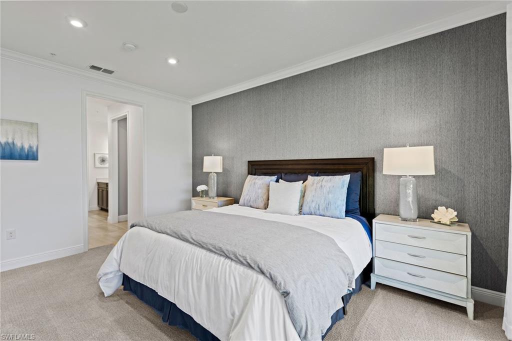 4558 Arboretum Circle, Unit 104 Naples, FL 34112 - Photo 13 of 19 a bedroom with a bed and a night stand