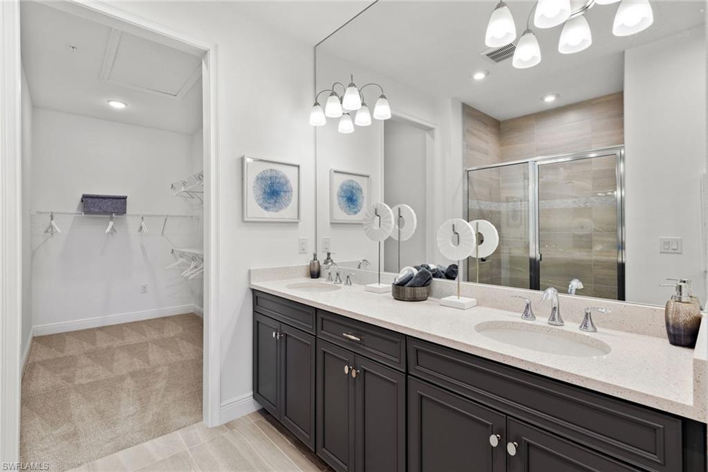 4558 Arboretum Circle, Unit 104 Naples, FL 34112 - Photo 15 of 19 a bathroom with a sink double vanity and a mirror