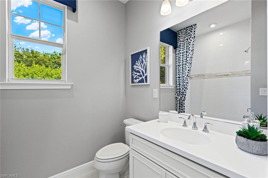4558 Arboretum Circle, Unit 104 Naples, FL 34112 - Photo 17 of 19 a bathroom with a sink a toilet and a mirror