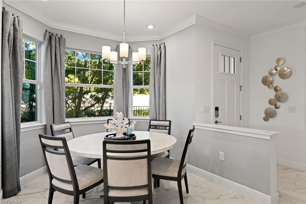 4558 Arboretum Circle, Unit 104 Naples, FL 34112 - Photo 3 of 19 a dining room with furniture a chandelier and wooden floor