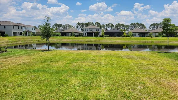 a view of residential houses with yard and lake view