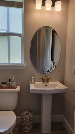 a bathroom with a toilet sink and mirror