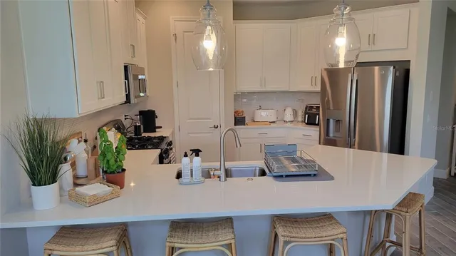 a kitchen with a table a refrigerator and a counter space